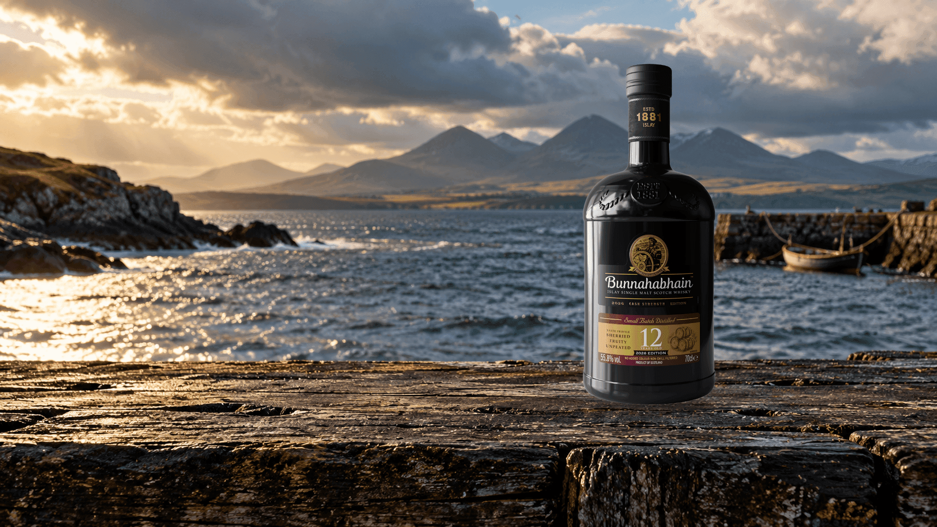 Bunnahabhain 12 Years Old Cask Strength 2026 Edition su una trave di un vecchio pontile sul Sound of Islay con i Paps of Jura sullo sfondo