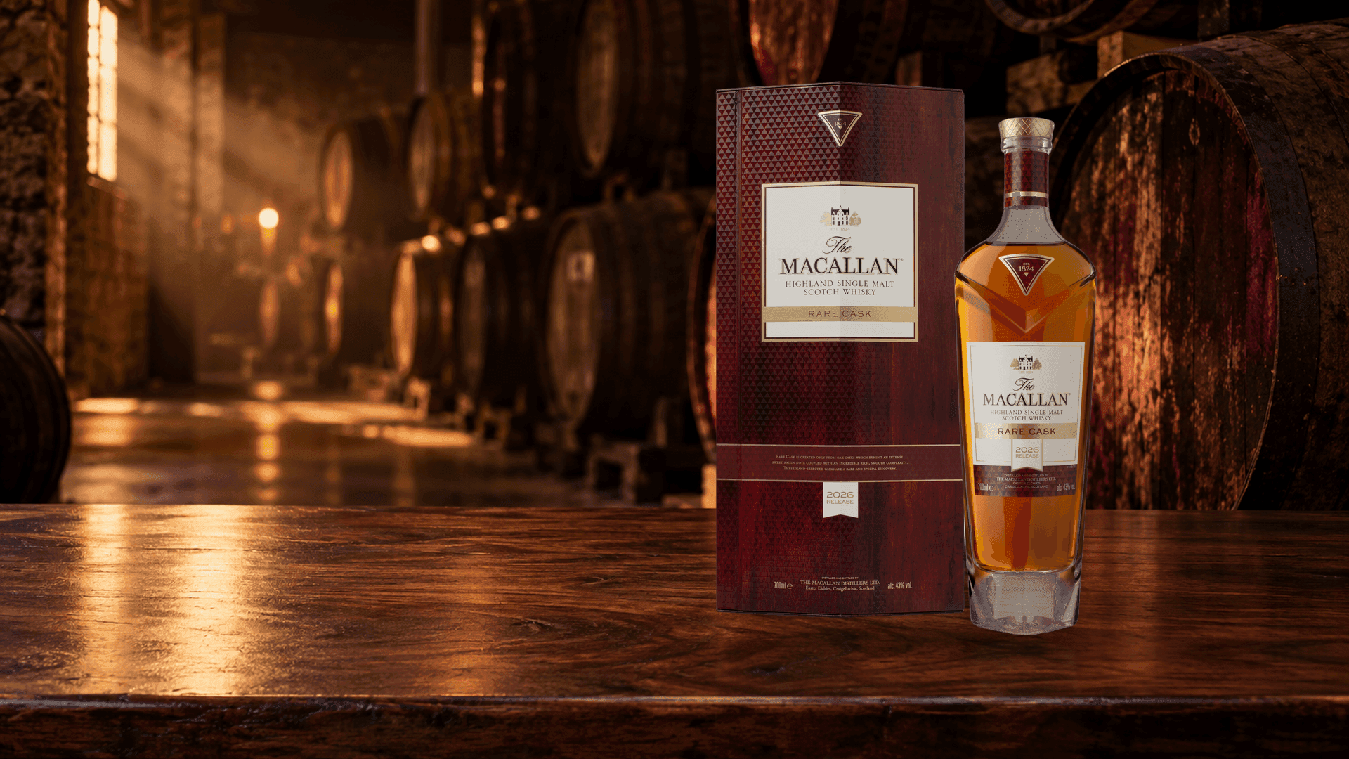 Botella y estuche de Macallan Rare Cask 2026 Release sobre una mesa de nogal en una bodega de barricas de jerez