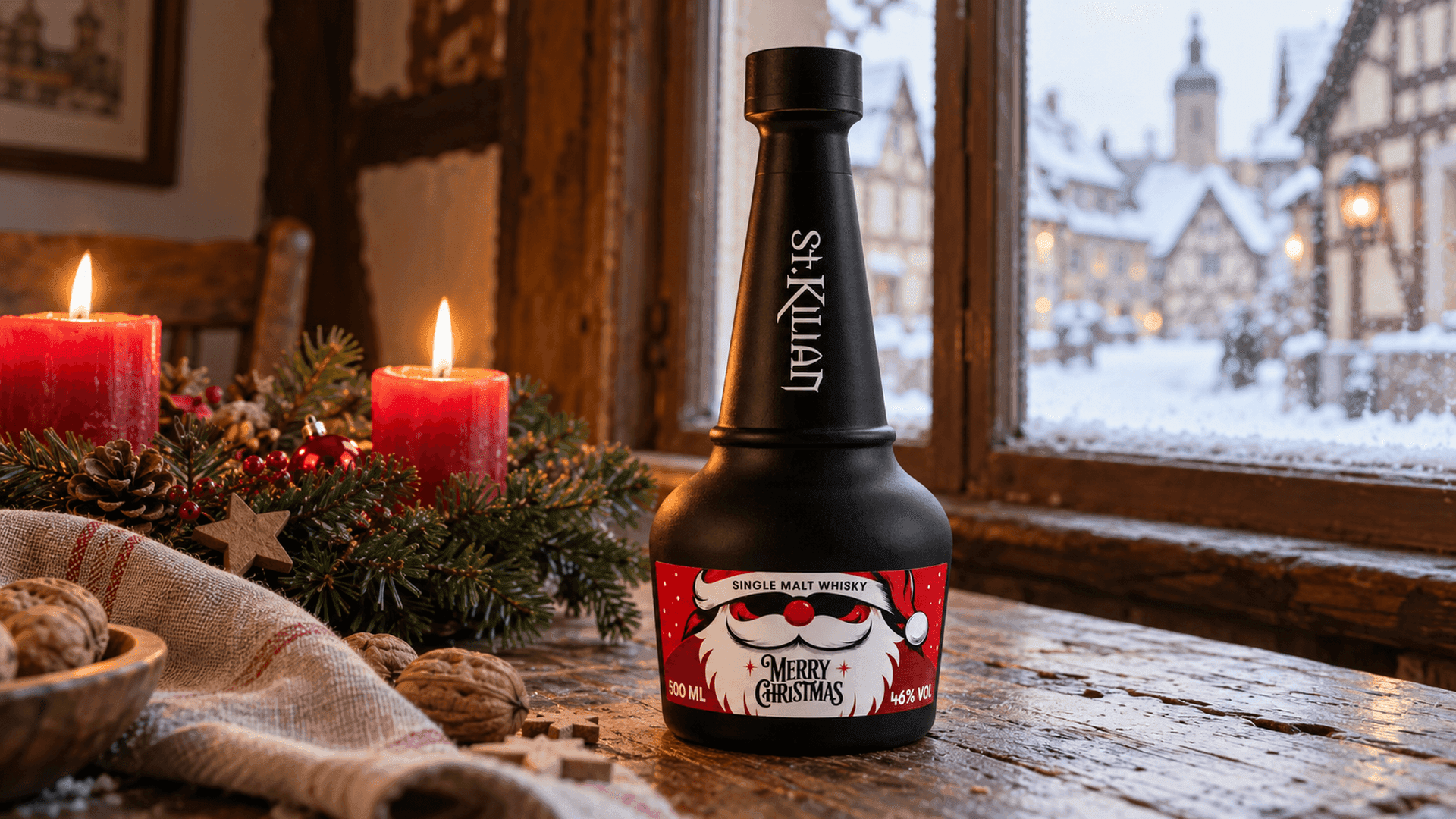 Matt schwarze St. Kilian Christmas Edition 2026 Flasche mit rotem Weihnachtsmann Etikett auf einem Holztisch am Fenster eines fränkischen Fachwerkhauses, mit Adventskranz und brennenden Kerzen und einem verschneiten Dorf draußen bei hellem Tageslicht